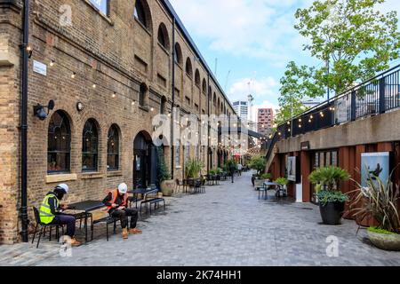 I lavoratori che prendono una pausa fuori da un bar in Lower Stable Street nella zona di riqualificazione di King's Cross, Londra, Regno Unito Foto Stock