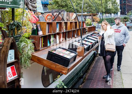 I clienti che navigano su Word on the Water, alias The London Bookbarge, una libreria galleggiante sul Regents Canal a King's Cross, Londra, Regno Unito Foto Stock