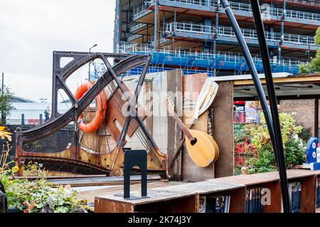 Strumenti musicali, una cornice per pianoforte e altri bric-a-brac su Word on the Water, una libreria galleggiante sul Regents Canal a King's Cross, Londra, Regno Unito Foto Stock