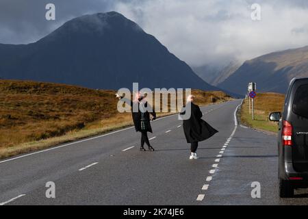 I turisti scattano foto nel mezzo della strada panoramica ma veloce e trafficata A82 attraverso Glencoe, Scozia, Regno Unito Foto Stock