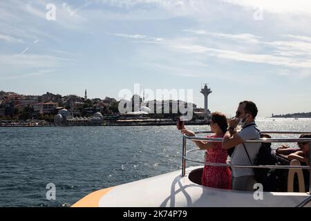 Vista dei turisti in barca da crociera sul Bosforo a ıstanbul. E' una giornata estiva di sole. Foto Stock