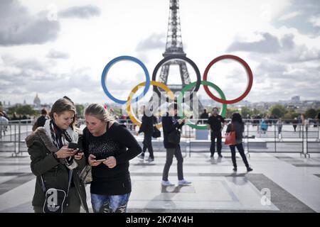 Gli anelli olimpici sono esposti a Place du Trocadero vicino alla Torre Eiffel (vista sul retro) per celebrare l'annuizio della vittoriosa offerta olimpica di Parigi del 2024, a Parigi, in Francia, il 14 settembre 2017. Foto Stock