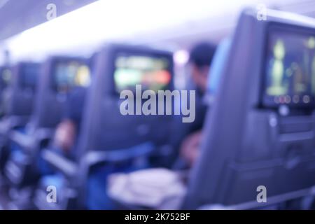 Vista blu dei sedili vuoti degli aerei passeggeri in cabina di colore viola Foto Stock