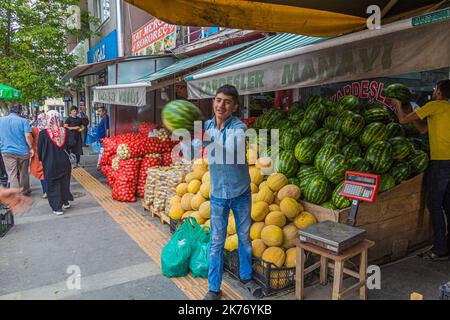 KARS, TURCHIA - 18 LUGLIO 2019: Lavoratori che gettano e catturano meloni in un negozio di frutta e verdura a Kars, Turchia Foto Stock