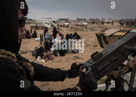 Il PG curdo della coalizione (forze democratiche siriane AKA SDF) sta portando migliaia di donne e bambini dei jihadisti di Daesh (ISIS) fuori da Baghouz, l'ultima roccaforte jihadista in Siria, in camion per farli cadere nel campo di al Hol a poche ore di distanza. Foto Stock