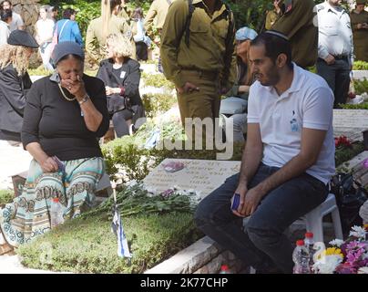 Un soldato israeliano siede accanto alle tombe dei soldati caduti nel Mt. Cimitero militare di Herzl a Gerusalemme, in occasione della Giornata della memoria di Israele per i soldati e le vittime del terrore, 8 maggio 2019. Migliaia di israeliani si sono riuniti in cimiteri militari in tutto il paese per ricordare 23.741 soldati e 3.150 vittime del terrorismo. Foto Stock