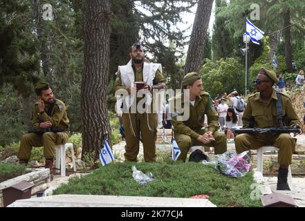 Un soldato israeliano siede accanto alle tombe dei soldati caduti nel Mt. Cimitero militare di Herzl a Gerusalemme, in occasione della Giornata della memoria di Israele per i soldati e le vittime del terrore, 8 maggio 2019. Migliaia di israeliani si sono riuniti in cimiteri militari in tutto il paese per ricordare 23.741 soldati e 3.150 vittime del terrorismo. Foto Stock