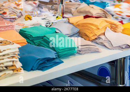 Primo piano di diverse pile di sfridi di tessuto per la lavorazione dell'ago. Concetto di lavoro a cucito, hobby Foto Stock