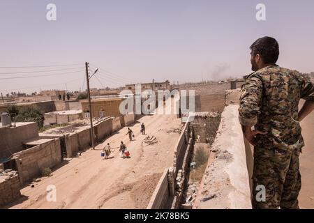 Un comandante YPG (forze curde) delle forze democratiche siriane (SDF) guarda i suoi soldati portare acqua brailes alla base successiva. Foto Stock