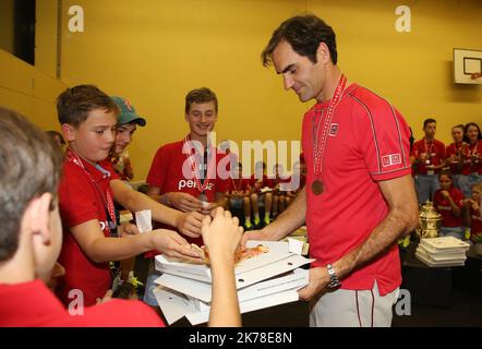 Il svizzero Roger Federer mangia pizza con i bambini della palla dopo aver sconfitto l'australiano Alex De Minaur durante la partita finale al torneo di tennis Swiss Indoor ATP500 che si terrà a Basilea il 27 ottobre 2019 Foto Stock