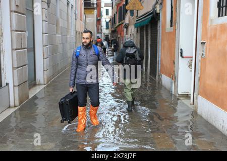 Venezia sott'acqua mentre la marea eccezionale attraversa la città dei canali. La gente cammina attraverso una città allagata nelle strade vicino a St. Piazza Marco il 17 novembre 2019 a Venezia. Gran parte di Venezia è stata lasciata sott'acqua dopo la marea più alta in 50 anni strappata attraverso la storica città italiana, behing gondole, travolgendo alberghi e inviando turisti in fuga attraverso acque in rapido aumento. Foto Stock