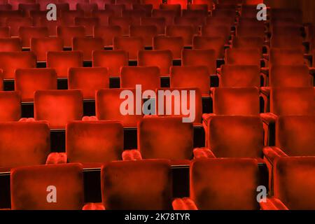 Sedie rosse in velluto in un teatro, evidenziando la simmetria, le linee e la ripetizione dei sedili. Foto Stock