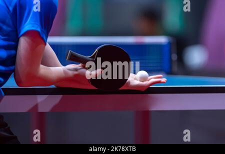 Tavolo da ping pong, donna professionista che gioca a ping pong con racchetta e palla in una sala sportiva Foto Stock