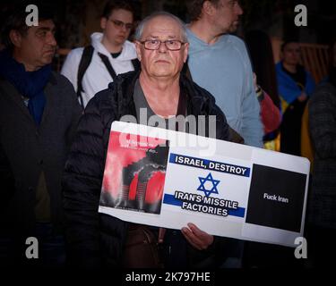 Un uomo ha un segno durante una protesta a Varsavia, in Polonia, il 17 ottobre 2022. Diverse centinaia di persone si sono riunite davanti all'ambasciata iraniana per protestare Foto Stock