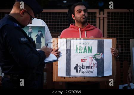 Un uomo ha un segno durante una protesta a Varsavia, in Polonia, il 17 ottobre 2022. Diverse centinaia di persone si sono riunite davanti all'ambasciata iraniana per protestare Foto Stock