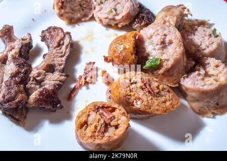 Salsiccia arrostita e affettata su un piatto bianco con piccoli pezzi di carne accanto al sapore della salsiccia è il pastrami. Foto Stock