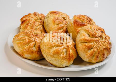 samsa fritta con agnello ripieno su un piatto bianco, un popolare spuntino asiatico. Foto Stock