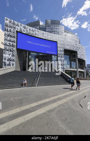 Un'installazione di artisti di strada francesi JR, composta da ritratti di personale medico, adorna la facciata della Bastille Opera House, insieme al messaggio 'grazie ai nostri professionisti sanitari', come omaggio agli operatori sanitari che hanno contribuito alla lotta contro il coronavirus (covid-19). Foto Stock