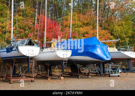 Barche a vela su culle in un deposito all'aperto in autunno Foto Stock