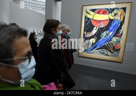 ©PHOTOPQR/L'EST REPUBLICAIN/ALEXANDRE MARCHI ; METZ ; 11/12/2020 ; CULTURA - ESPOSIZIONE MARC CHAGALL PASSEUR DE LUMIERE - MUSEE - PEINTURE - DESSERT - COLLAGES - VITRAUX - SIGNATURE - AUTOGRAPHE. Centre Pompidou-Metz 11 dicembre 2020. Des personnes portant des masques de Protection regarde'le Monde rouge et noir ou Soleil rouge', carton de tapisserie, (1951) dans l'exposition inédite 'Chagall. Passeur de lumière' sur 1200 m² en galerie 3 du Centre Pompidou-Metz jusqu'au 26 avril 2021. FOTO Alexandre MARCHI. - Metz, Francia, 11th 2020 dicembre - Mostra Marc Chagall. L'Emissario della luce a CE Foto Stock