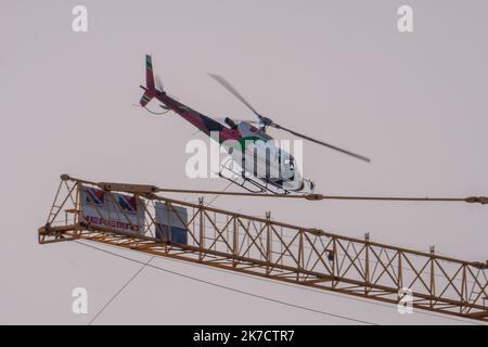 ©Arnaud BEINAT/Maxppp. 2021/02/24, Metz, Mosella, Francia. Un hélicoptère de la société Blugeon transporte des poutrelles métalliques a l'élingue pour la construction d'une tribune du stade de football Saint-Symphorien de Metz Foto Stock