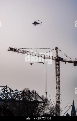 ©Arnaud BEINAT/Maxppp. 2021/02/24, Metz, Mosella, Francia. Un hélicoptère de la société Blugeon transporte des poutrelles métalliques a l'élingue pour la construction d'une tribune du stade de football Saint-Symphorien de Metz Foto Stock