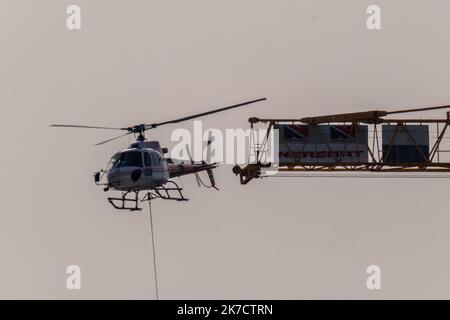 ©Arnaud BEINAT/Maxppp. 2021/02/24, Metz, Mosella, Francia. Un hélicoptère de la société Blugeon transporte des poutrelles métalliques a l'élingue pour la construction d'une tribune du stade de football Saint-Symphorien de Metz Foto Stock