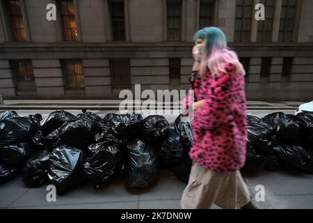 New York, Stati Uniti. 8 febbraio 2021. Una donna passa accanto a un mucchio di sacchi di spazzatura non raccolti a Lower Manhattan, dopo che due tempeste di neve hanno colpito New York in una settimana, 8 febbraio 2021. Il Department of Sanitation of New York sta riprendendo la raccolta dei rifiuti dopo aver incaricare i suoi dipendenti e camion per arare la neve nei cinque quartieri di New York City. (Foto di Anthony Behar/Sipa USA) Credit: Sipa USA/Alamy Live News Foto Stock