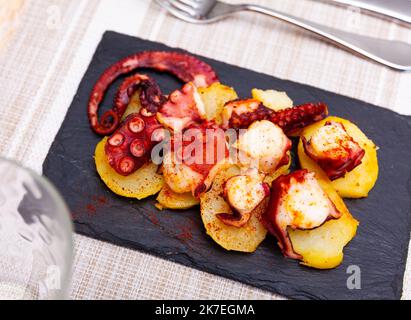 Porzione di polbo a feira servita a bordo Foto Stock