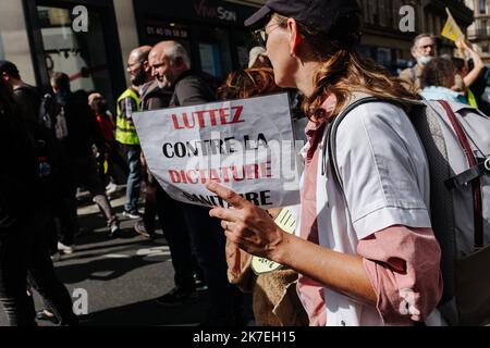 ©Jan Schmidt-Whitley/le Pictorium/MAXPPP - Jan Schmidt-Whitley/le Pictorium - 7/8/2021 - Francia / Ile-de-France / Parigi - une femme porte une pancarte contre la dictature sanitaire. Sous une Protection politiere renforcee, plusieurs milliers de manifestants se sont elances du pont de Neuilly avant de rejoindre la Place de l'Hotel de Ville pour temoigner leur opposion au passe sanitaire, trois jours apres l'aval du Conseil constitutionnel. / 7/8/2021 - Francia / Ile-de-France (regione) / Parigi - sotto la pesante sorveglianza della polizia, diverse migliaia di manifestanti si sono staccati dal ponte Neuilly bfo Foto Stock