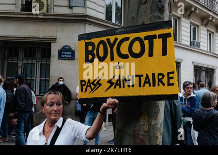 ©Jan Schmidt-Whitley/le Pictorium/MAXPPP - Jan Schmidt-Whitley/le Pictorium - 7/8/2021 - Francia / Ile-de-France / Parigi - une manifestante porte une pancarte contre le Pass sanitaire avec une reference a l'Allemagne nazie. Sous une Protection politiere renforcee, plusieurs milliers de manifestants se sont elances du pont de Neuilly avant de rejoindre la Place de l'Hotel de Ville pour temoigner leur opposion au passe sanitaire, trois jours apres l'aval du Conseil constitutionnel. / 7/8/2021 - Francia / Ile-de-France (regione) / Parigi - sotto pesante sorveglianza di polizia, diverse migliaia di dimostranti Foto Stock