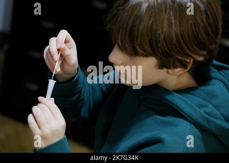 ©PHOTOPQR/LE PARISIEN/Jean-Baptiste Quentin ; Paris ; 17/12/2021 ; Crise sanitaire du Covid-19 Illustration un enfant faisant un autotest, auto-test, Les autotests nasaux : il s'agit de tests antigéniques dont le prélèvement et la lecture du résultat peuvent être réalisés seul, d'après les indications fournies par un professionnel et après lecture des conditions d'utilitation et du « guide d'utilitation » fournis au moment de l'achat. Le mode de prélèvement autorisé aujourd’hui est l’auto-prélèvement nasal, qui est moins profond que le prélèvement nasopharyngé pratiqué pour les tests PCR et a. Foto Stock