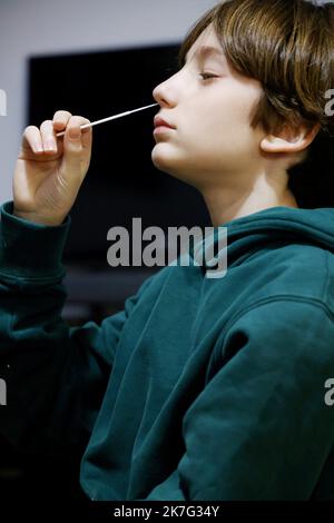 ©PHOTOPQR/LE PARISIEN/Jean-Baptiste Quentin ; Paris ; 17/12/2021 ; Crise sanitaire du Covid-19 Illustration un enfant faisant un autotest, auto-test, Les autotests nasaux : il s'agit de tests antigéniques dont le prélèvement et la lecture du résultat peuvent être réalisés seul, d'après les indications fournies par un professionnel et après lecture des conditions d'utilitation et du « guide d'utilitation » fournis au moment de l'achat. Le mode de prélèvement autorisé aujourd’hui est l’auto-prélèvement nasal, qui est moins profond que le prélèvement nasopharyngé pratiqué pour les tests PCR et a. Foto Stock