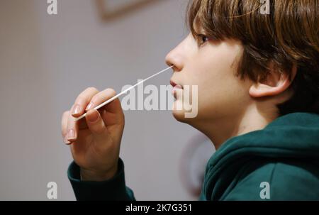 ©PHOTOPQR/LE PARISIEN/Jean-Baptiste Quentin ; Paris ; 17/12/2021 ; Crise sanitaire du Covid-19 Illustration un enfant faisant un autotest, auto-test, Les autotests nasaux : il s'agit de tests antigéniques dont le prélèvement et la lecture du résultat peuvent être réalisés seul, d'après les indications fournies par un professionnel et après lecture des conditions d'utilitation et du « guide d'utilitation » fournis au moment de l'achat. Le mode de prélèvement autorisé aujourd’hui est l’auto-prélèvement nasal, qui est moins profond que le prélèvement nasopharyngé pratiqué pour les tests PCR et a. Foto Stock