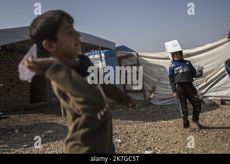 ©Christophe Petit Tesson/MAXPPP - 26/11/2021 ; HASSAN SHAM ; IRAQ - un enfant lance un avion en papier au 'camp U3' a Hassan Sham, a 30 km a l'est de Mossoul, le camp est sorveglianza commune des autorites kurde et Irakienne. Un espace de ce camp de reifies est Reserve aux anciens mineurs combattant de l'Etat Islamique, non condamne par la justice ils n'ont pas le droit de sortir du camp . U3 campo a Hassan Sham. Questo campo profughi a 30 km a est di Mosul è gestito dalle autorità curde. Una zona nel campo è riservata ai giovani combattenti dell'ex Stato islamico, non condannati da jcourt che fanno Foto Stock