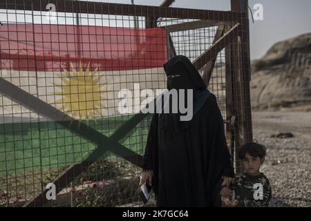 ©Christophe Petit Tesson/MAXPPP - 26/11/2021 ; HASSAN SHAM ; IRAQ - une femme portant un niqab noir et son fils attendente a l'entree du 'camp U3' a Hassan Sham, a 30 km a l'est de Mossoul, le camp est sorveglianza commune des autorites kurde et irakienne. Un espace de ce camp de reifies est Reserve aux anciens mineurs combattant de l'Etat Islamique, non condamne par la justice ils n'ont pas le droit de sortir du camp . Una donna che indossa un niqab nero e suo figlio aspettano all'ingresso del campo 'U3' di Hassan Sham. Questo campo profughi a 30 km a est di Mosul è gestito dall'autorità curda Foto Stock
