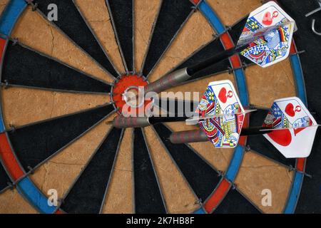 Regolamento Dart Board primo piano con le pinne di carte da gioco Foto Stock