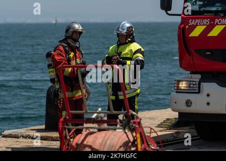 ©Nicolas Beaumont / le Pictorium/MAXPPP - Fos-sur-Mer 18/05/2022 Nicolas Beaumont / le Pictorium - 18/5/2022 - Francia / Provence-Alpes-Cote d'Azur / Fos-sur-Mer - Deux pompiers, dos a la mer, font le point a cote d'un vehulule. / 18/5/2022 - Francia / Provence-Alpes-Cote d'Azur / Fos-sur-Mer - due vigili del fuoco, con le loro spalle al mare, fare il punto vicino ad un veicolo. Foto Stock