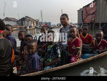 ©Sadak Souici / le Pictorium/MAXPPP - Lagos 20/01/2022 Sadak Souici / le Pictorium - 20/1/2022 - Nigeria / Lagos - une pirogue fait embarquer une poignee d'enfants patientant sans bruit devant leurs freles maisons de plantes sur pilotis. Makoko, Lagos, 20/01/2022 / 20/1/2022 - Nigeria / Lagos - Una canoa dugout trasporta una manciata di bambini che aspettano tranquillamente di fronte alle loro case di legno fragile su palafitte. Makoko, Lagos, 20/01/2022 Foto Stock