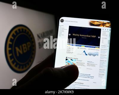 Persona che tiene il cellulare con la pagina web della banca centrale polacca Narodowy Bank Polski (NBP) sullo schermo con il logo. Messa a fuoco al centro del display del telefono. Foto Stock