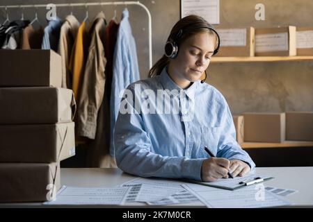 bella donna operatore seamstress cucire manager parlare sulla linea di assistenza calda fornendo assistenza ordine consegna abbigliamento centro showroom Foto Stock
