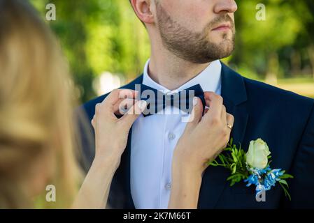 Imprenditore controllo tempo sul suo orologio da polso, uomo mettendo orologio sul lato,groom prepararsi al mattino prima cerimonia di nozze Foto Stock