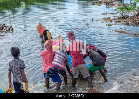 I devoti immergono Durga Idol sul fiume Ganges durante l'ultimo giorno del festival di Durga Puja Foto Stock