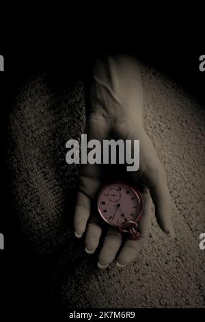 donna a mano aperta che tiene un orologio tascabile su un pavimento tappezzato, mistero thriller stile copertina libro. Foto Stock