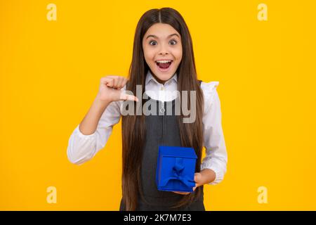 Ragazza teen stupita. Ritratto di ragazza bambino adolescente 12, 13, 14, anni tenendo in mano la scatola regalo di Natale. Regalo di compleanno per teen. Espressione eccitata Foto Stock