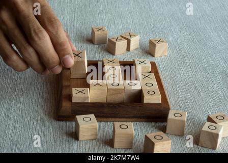 TIC tac TOE OX gioco fatto di blocchi di legno con giocatore a mano Foto Stock