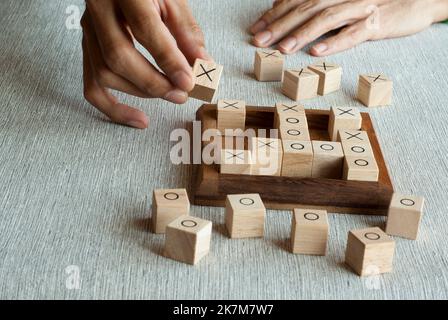 TIC tac TOE OX gioco fatto di blocchi di legno con giocatore a mano Foto Stock