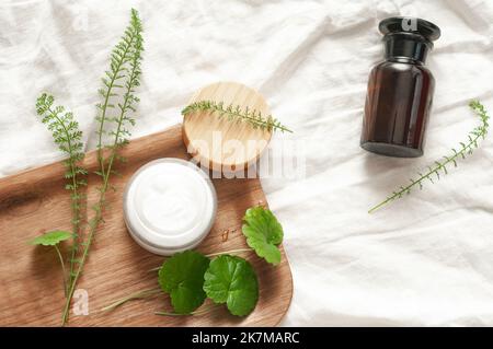 Concetto di sostenibilità sfondo cosmetico marrone vetro velo con prodotto piatto verde naturale bellezza naturale bblog concetto Foto Stock