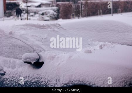 Un ritratto di due auto parcheggiate in un vialetto coperto di neve bianca durante l'inverno in una giornata nuvolosa. Il conducente dovrà pulire i finestrini prima di procedere alla guida Foto Stock