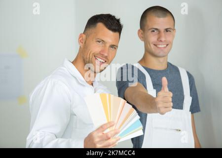 pittore che dà ok segno tenendo campione di colore Foto Stock